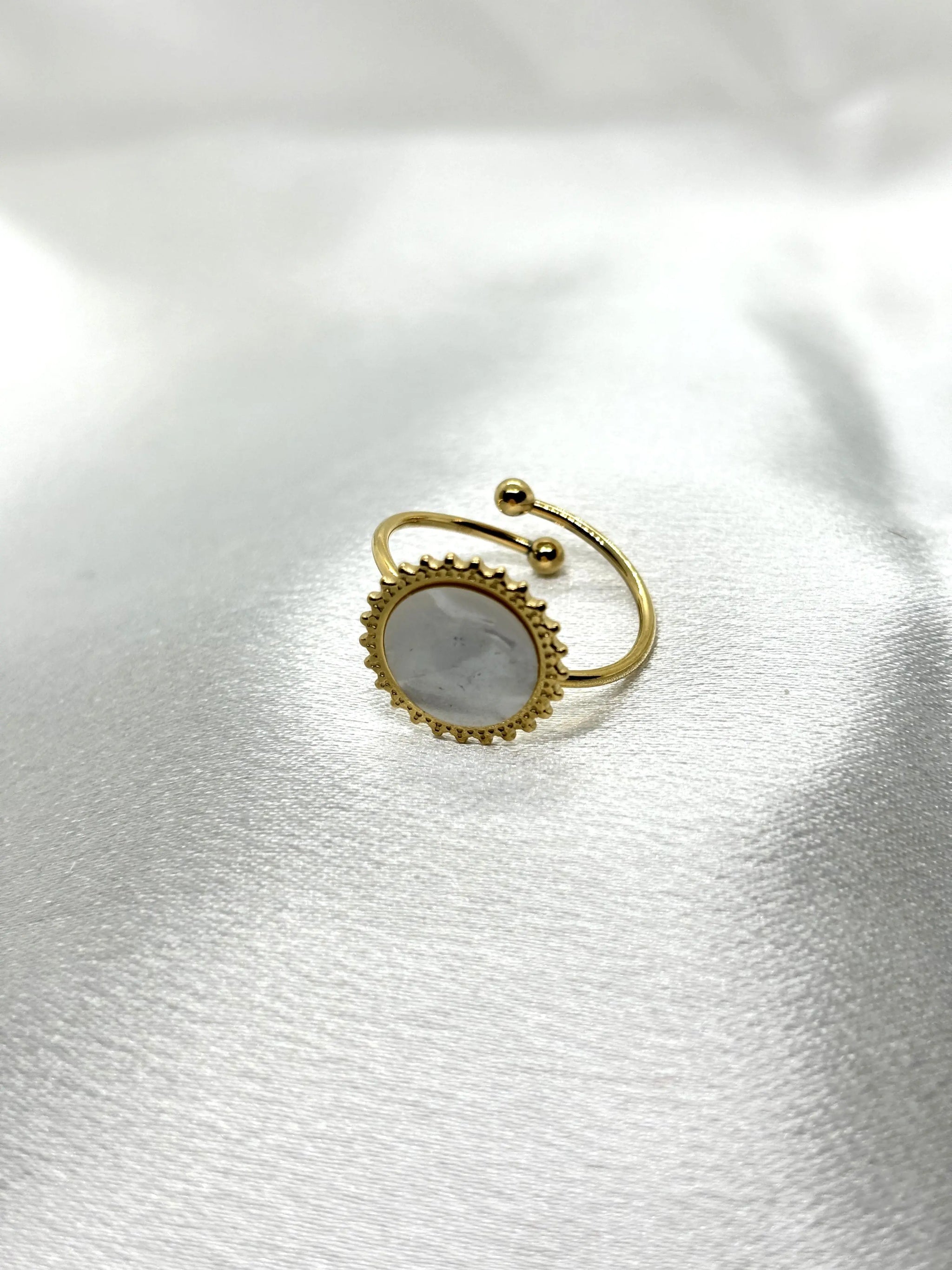 Bague chic dorée durable acier inoxydable femme avec pierre blanche élégante sur tissu satiné