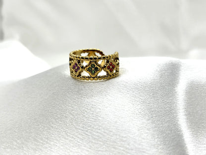 Bague dorée tendance TikTok avec pierres colorées élégantes sur fond blanc satiné