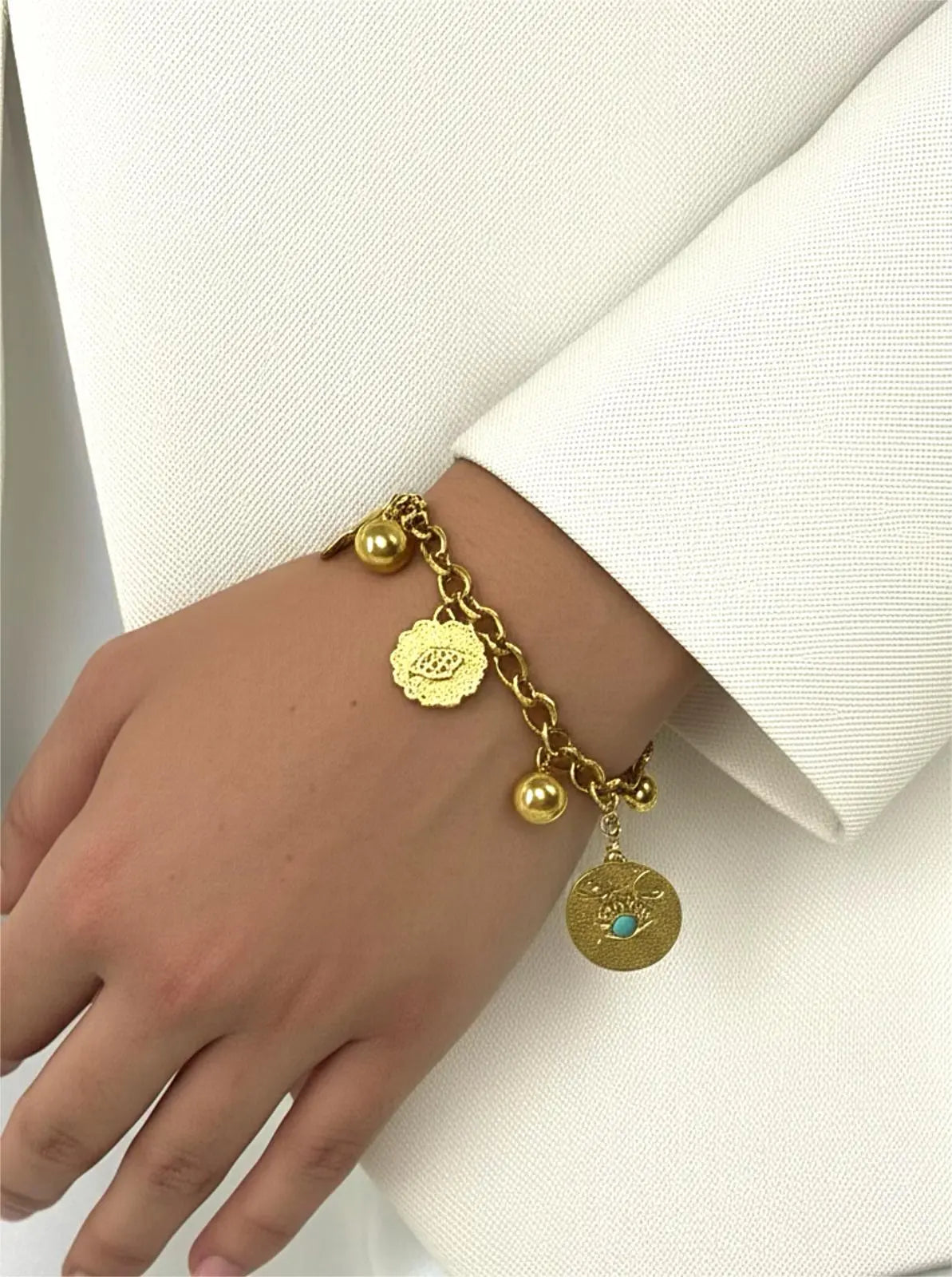 Bracelet doré œil porte-bonheur acier inoxydable femme porté au poignet avec pendentifs ronds