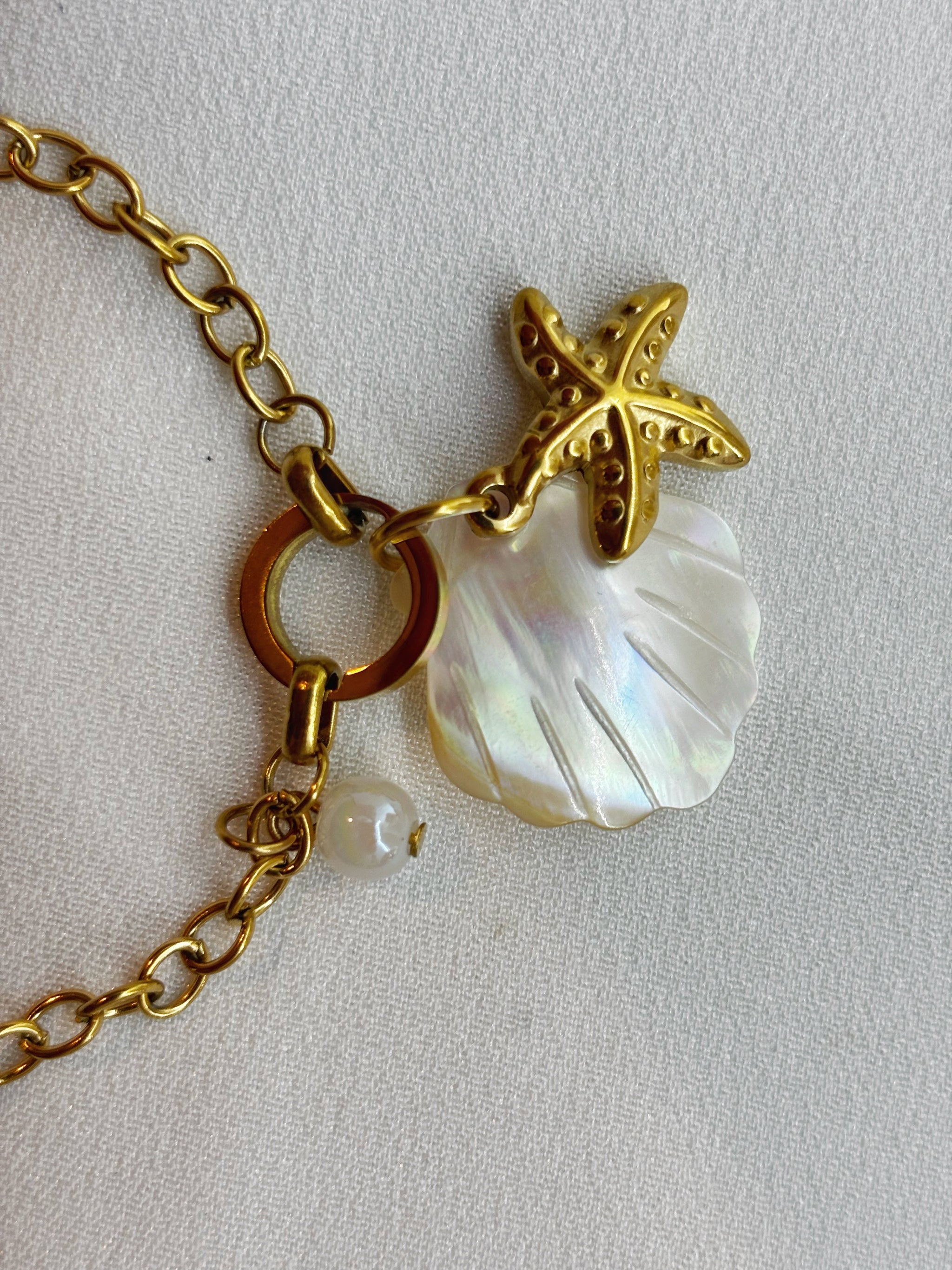 Bracelet femme coquillage acier inoxydable EVAYA avec chaîne dorée étoile de mer et coquillage nacré