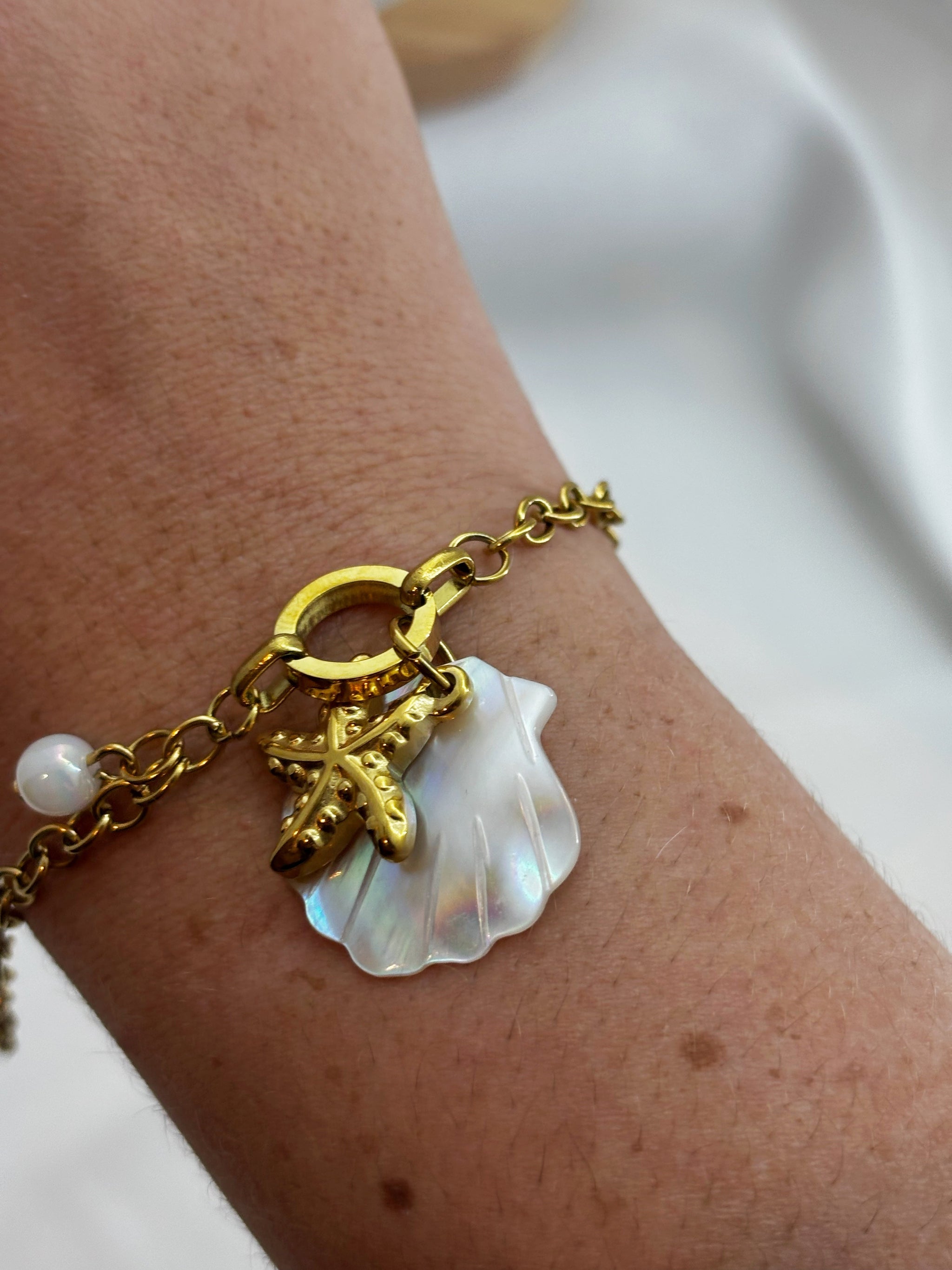 Bracelet femme coquillage acier inoxydable EVAYA avec pendentifs coquillage et étoile de mer dorés