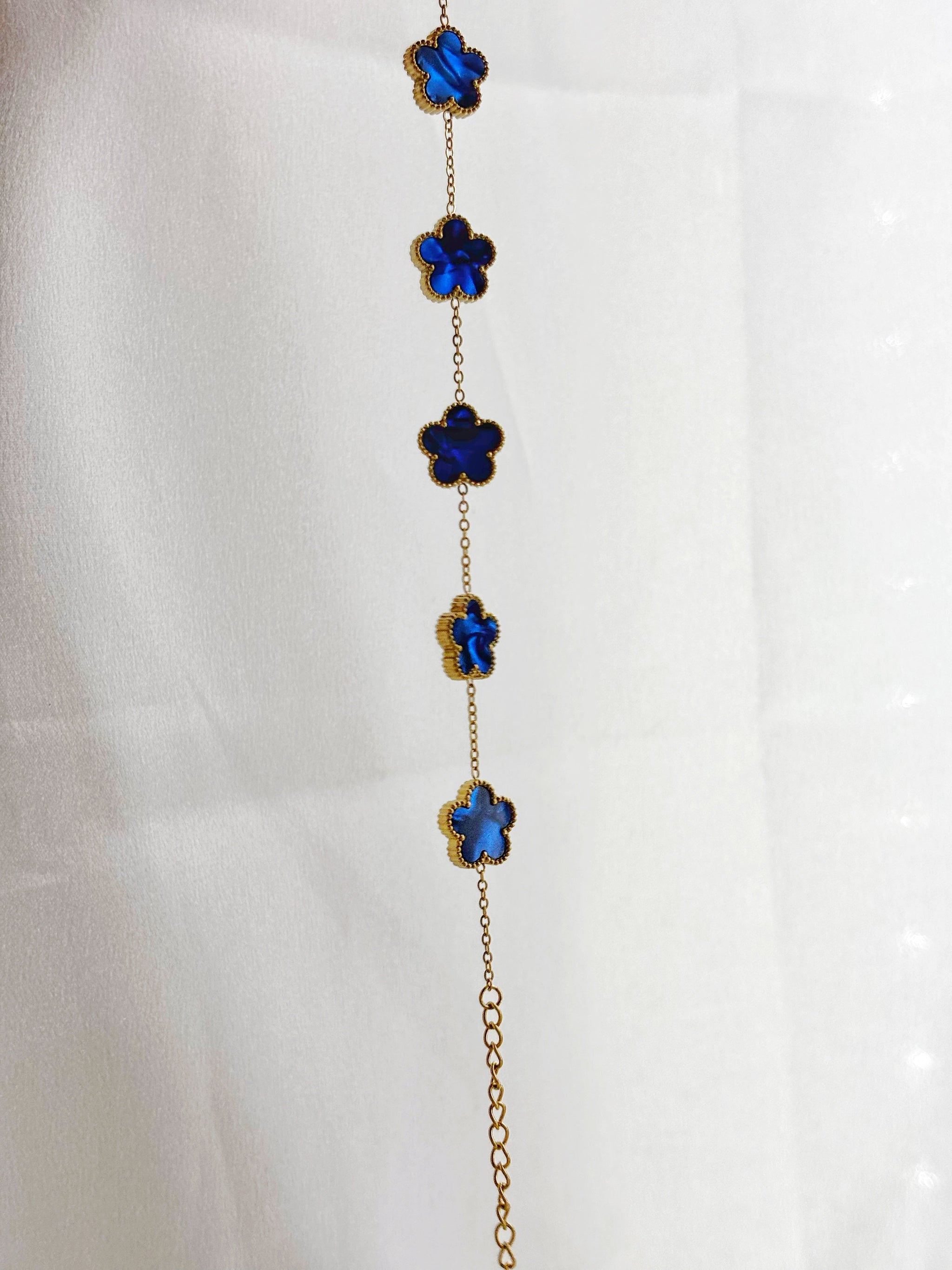 Bracelet fleur acier inoxydable EVAYA avec fleurs bleues enchaînées et finition dorée élégante