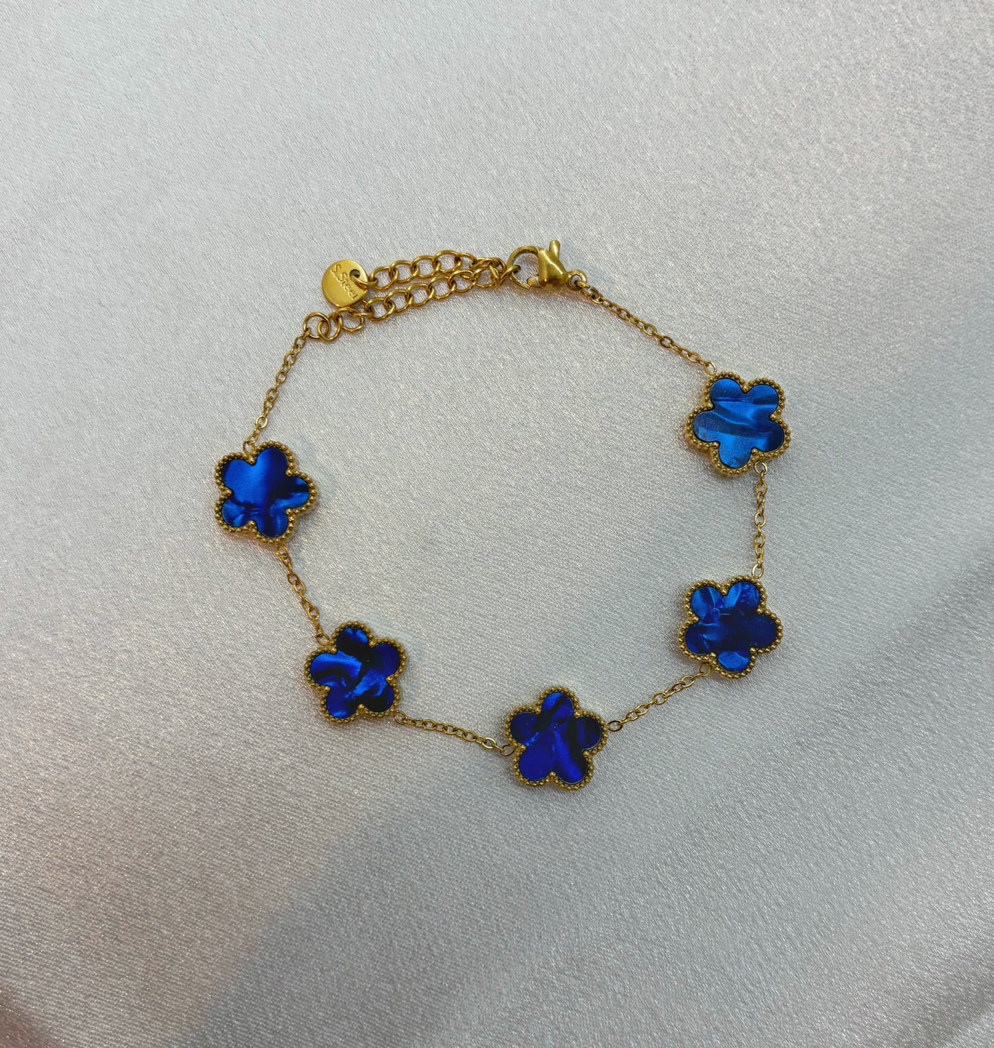 Bracelet fleur acier inoxydable EVAYA avec cinq fleurs bleues sur chaîne dorée délicate