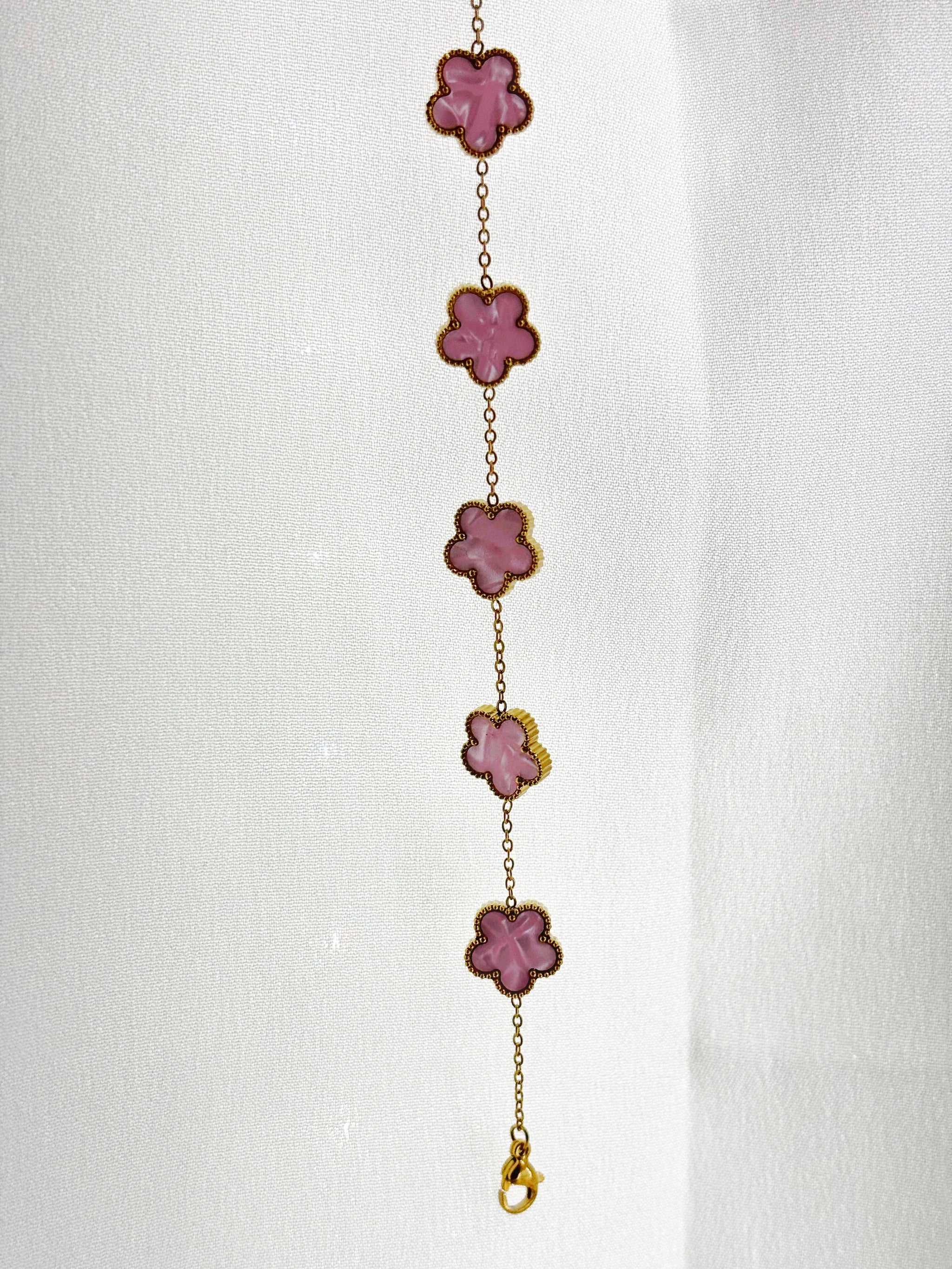 Bracelet fleur acier inoxydable EVAYA avec cinq fleurs roses reliées par une fine chaîne dorée