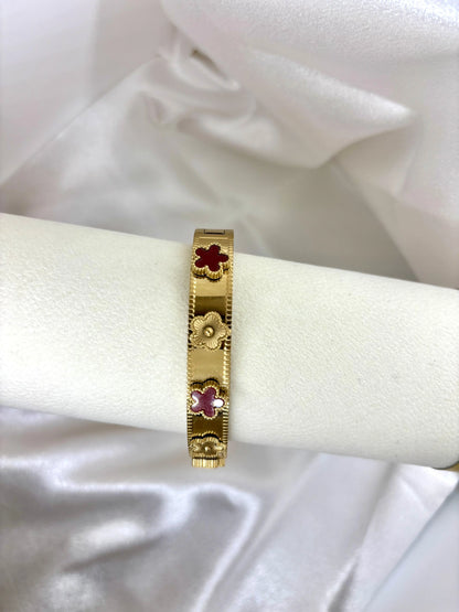 Bracelet jonc doré fleurs colorées acier inoxydable femme similaire louis vitton présenté sur support blanc