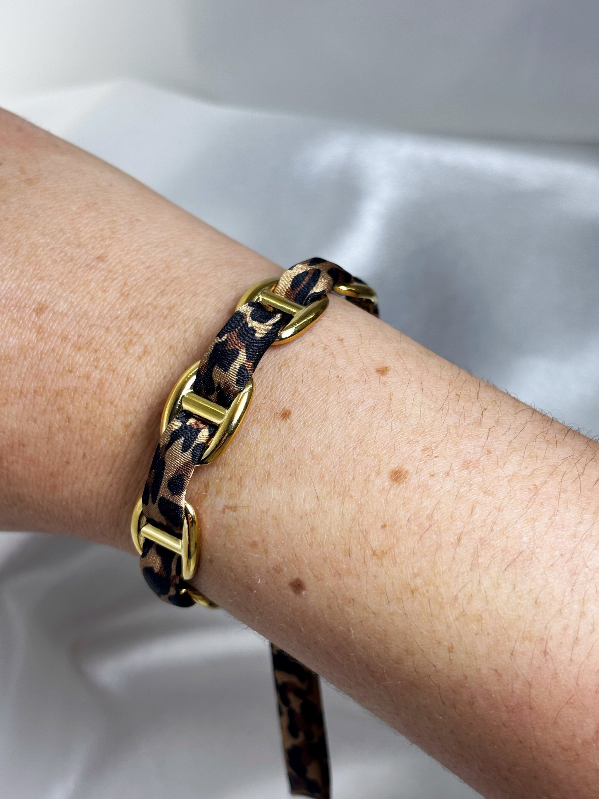 Bracelet manchette acier inoxydable léopard EVAYA avec maillons dorés et motif animalier sur poignet