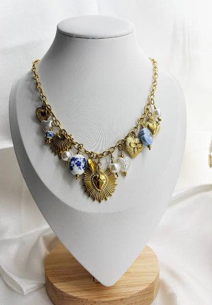 Collier original pendentifs dorés et perles sur chaîne dorée présenté sur un présentoir blanc