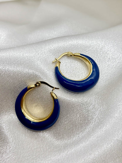 Boucles d'oreilles créoles or bleu acier inoxydable femme EVAYA sur fond de tissu blanc