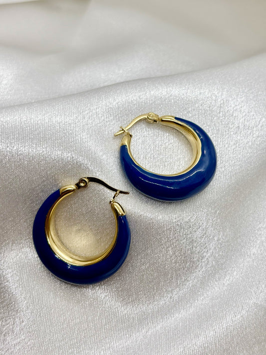 Boucles d'oreilles créoles or bleu acier inoxydable femme EVAYA sur fond de tissu blanc